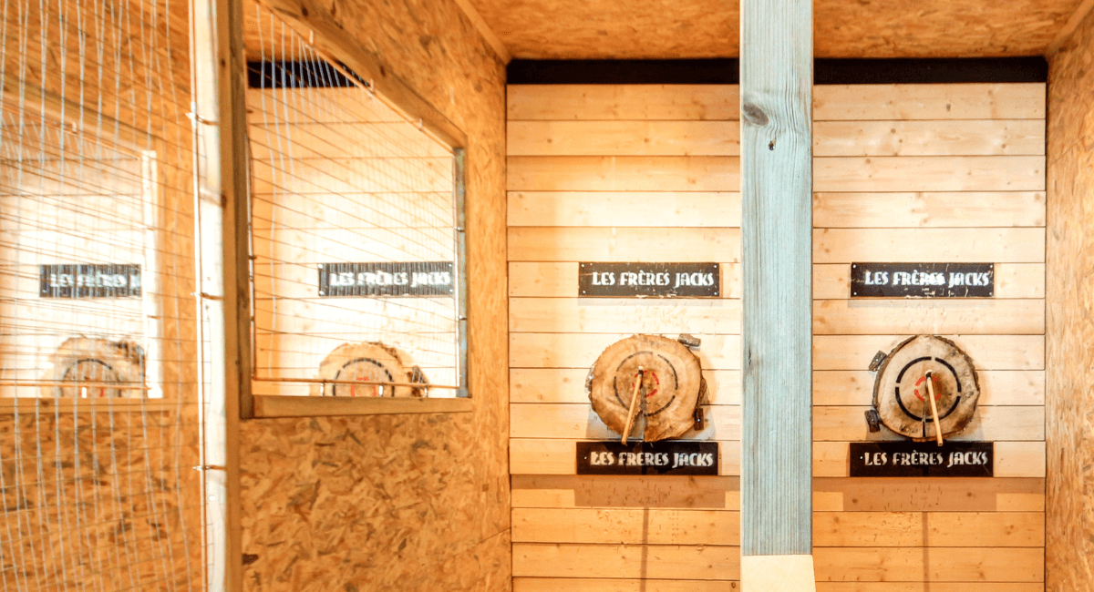 Box de lancer de hache en bois avec cibles et haches plantées chez Les Frères Jacks