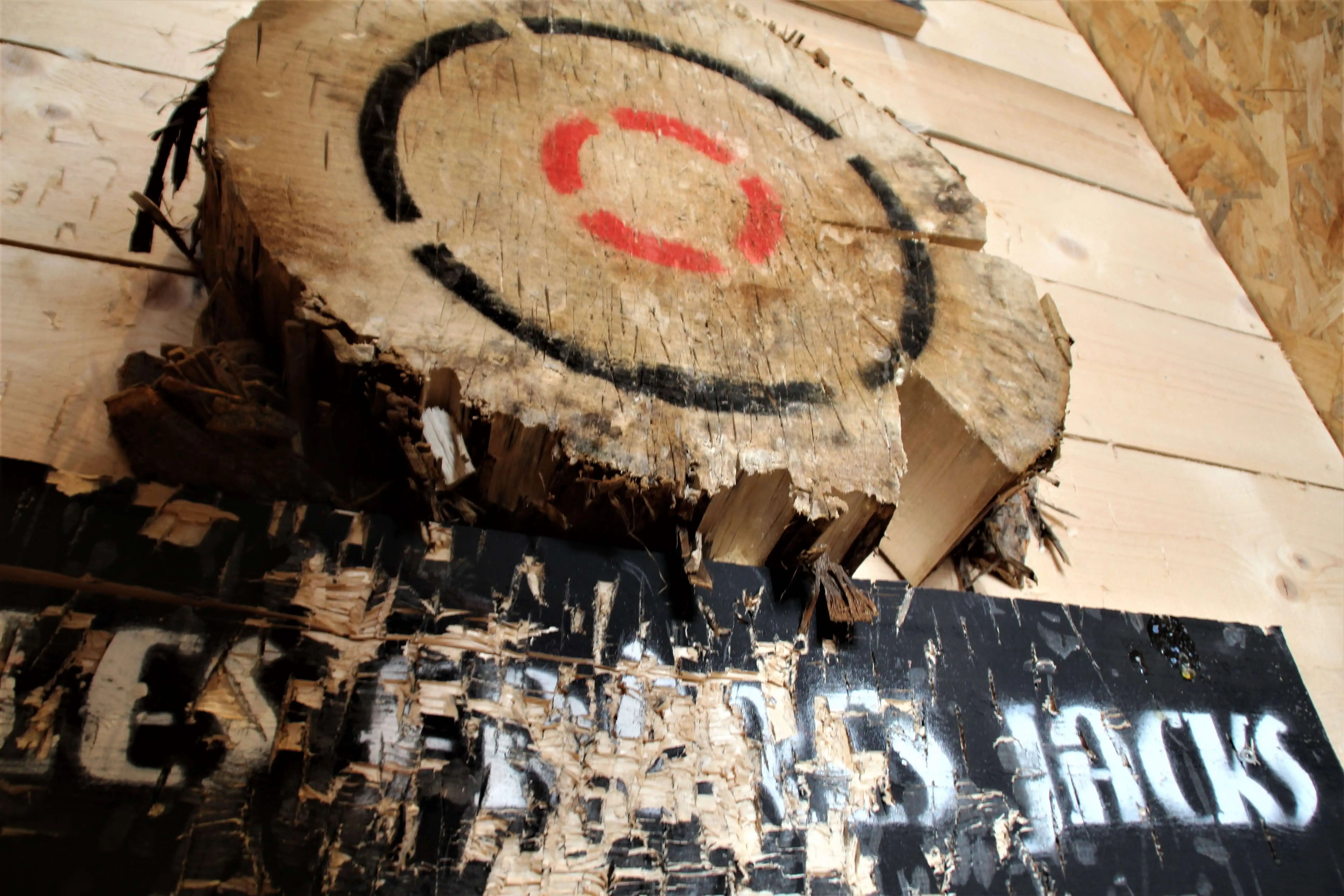 Cible en rondin de bois vue en contre-plongée, panneau Les Frères Jacks en dessous